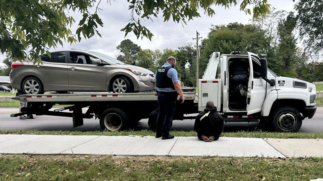 Tow truck flatbed carrying a vehicle during a St. Louis police theft investigation